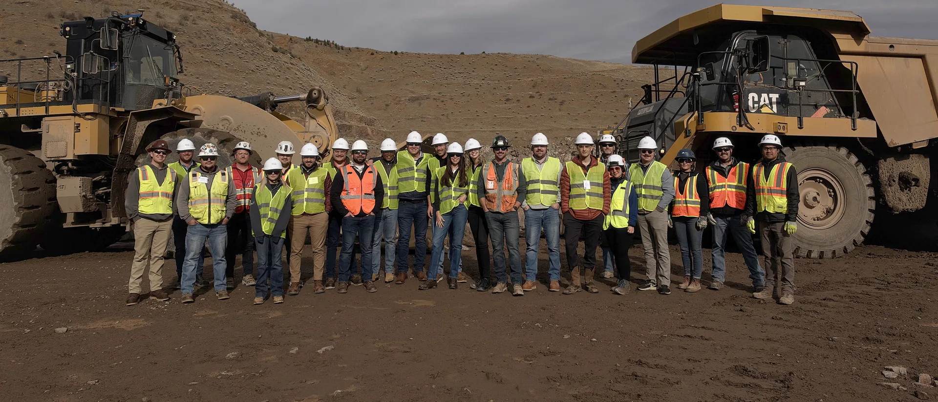NSSGA Young Leaders in hard hats and safety vests between a wheel loader and a haul truck at Martin Marietta’s Spec Agg quarry