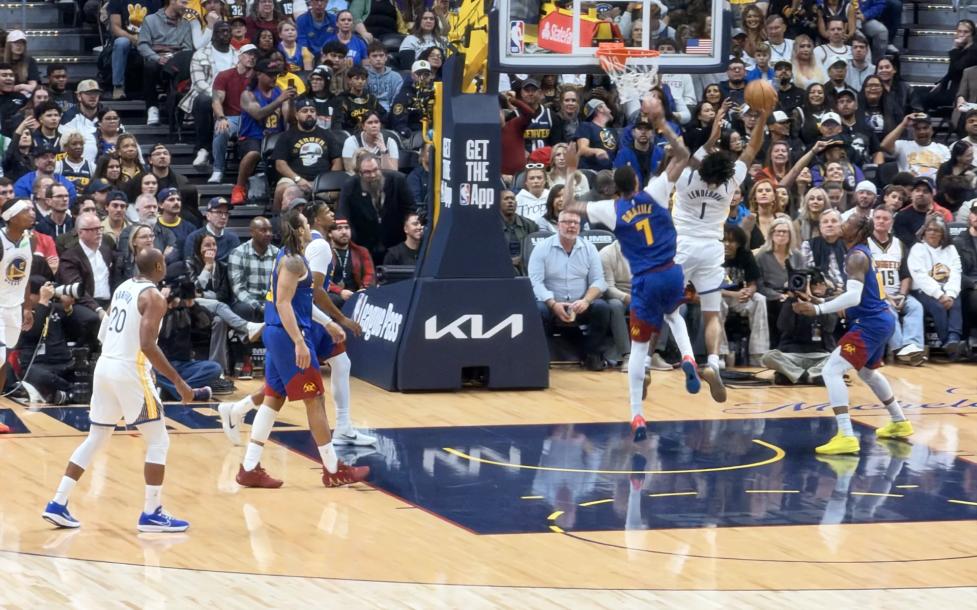 Nuggets and Warriors players under the basket at Ball Arena